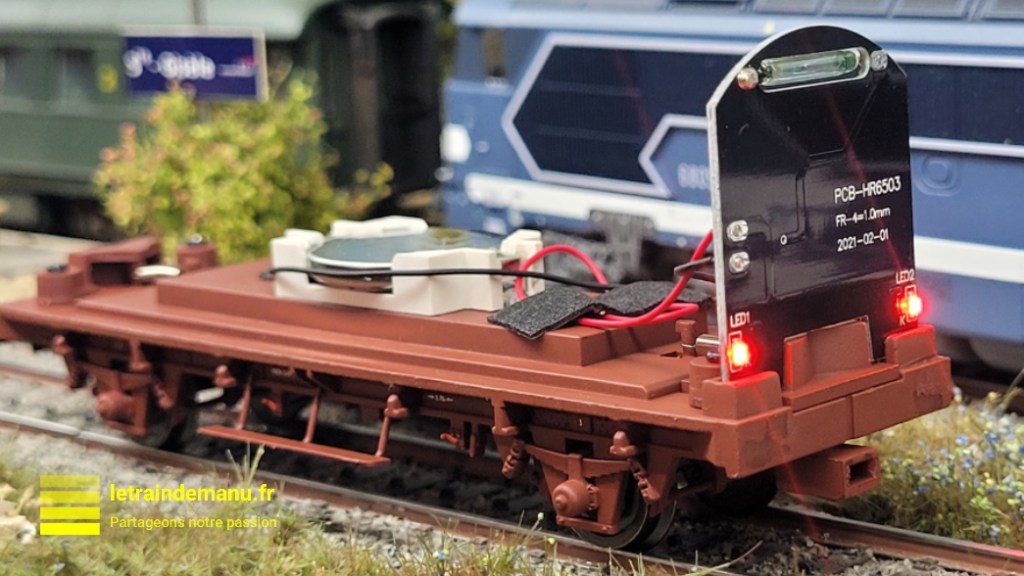 Intérieur et platine électronique du wagon couvert Jouef HJ 6291 équipé de feux de fin de convoi, ici vu sur le réseau de l'auteur