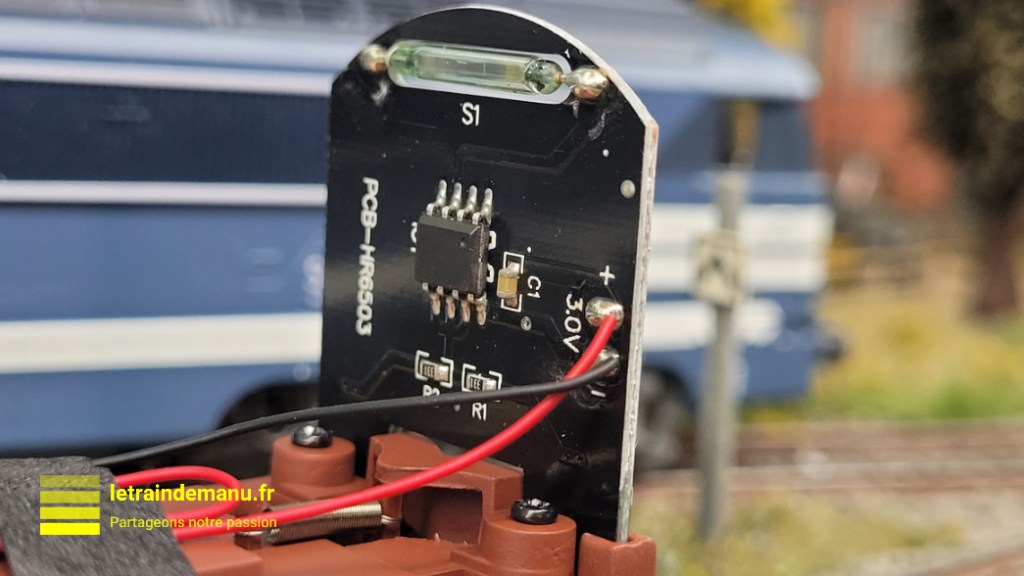 Intérieur et platine électronique du wagon couvert Jouef HJ 6291 équipé de feux de fin de convoi, ici vu sur le réseau de l'auteur. L'ILS est situé tout en haut, au-dessus de S1.